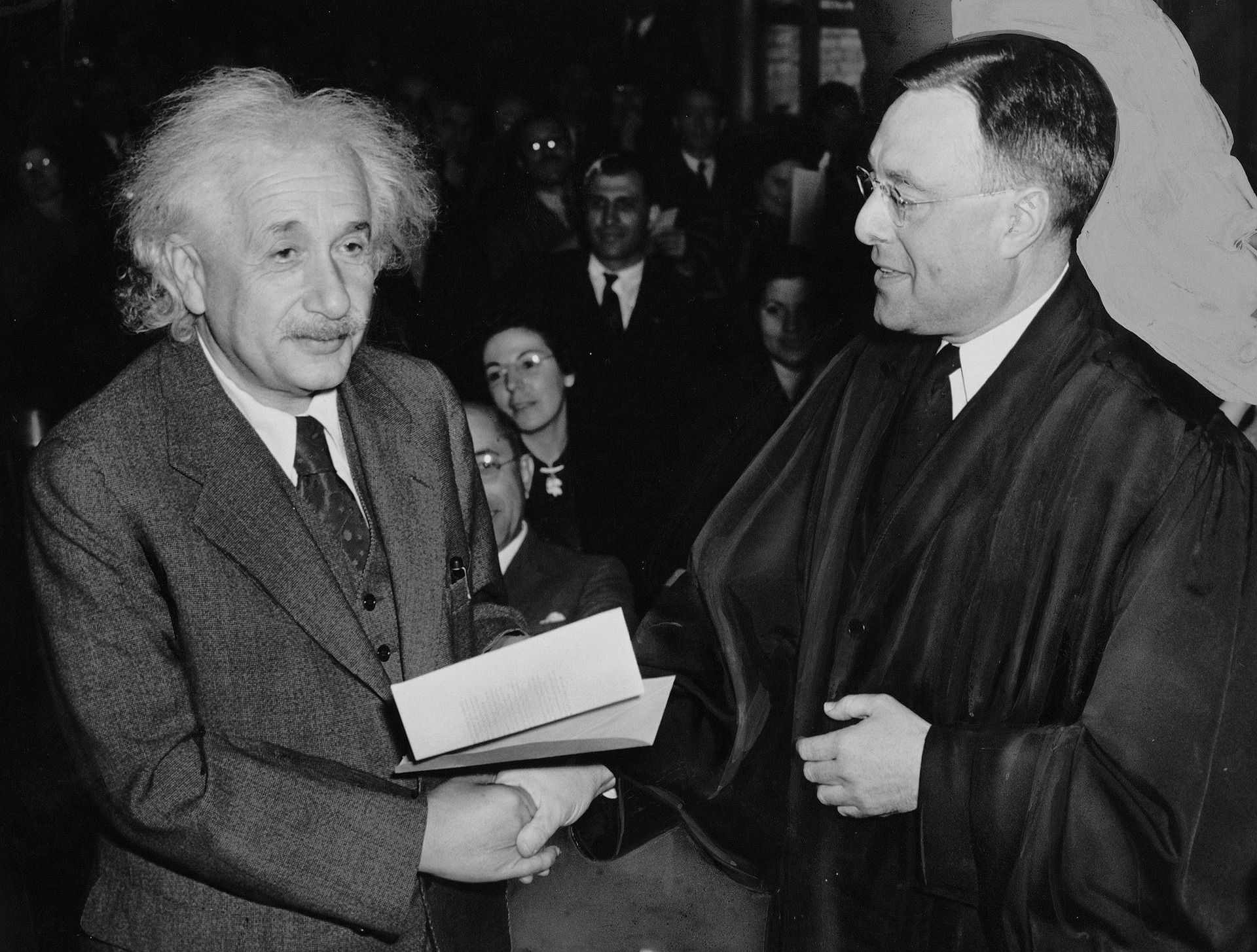 Albert Einstein shaking hands with man