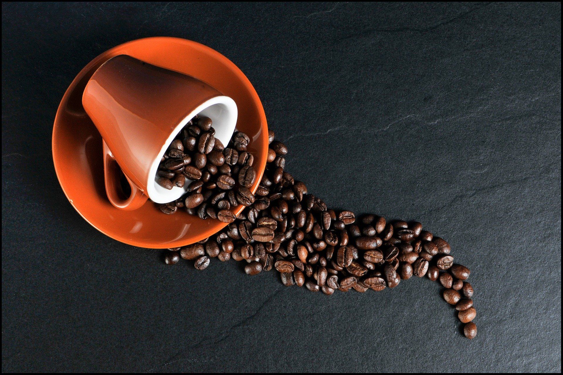 A spilled cup filled with coffee beans